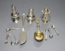 A Victorian silver butter knife, an ornate Dutch white metal spoon, seven condiment spoons including