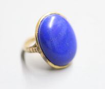 An early 20th century yellow metal and cabochon lapis lazuli set dress ring, size J, gross 8.4 grams