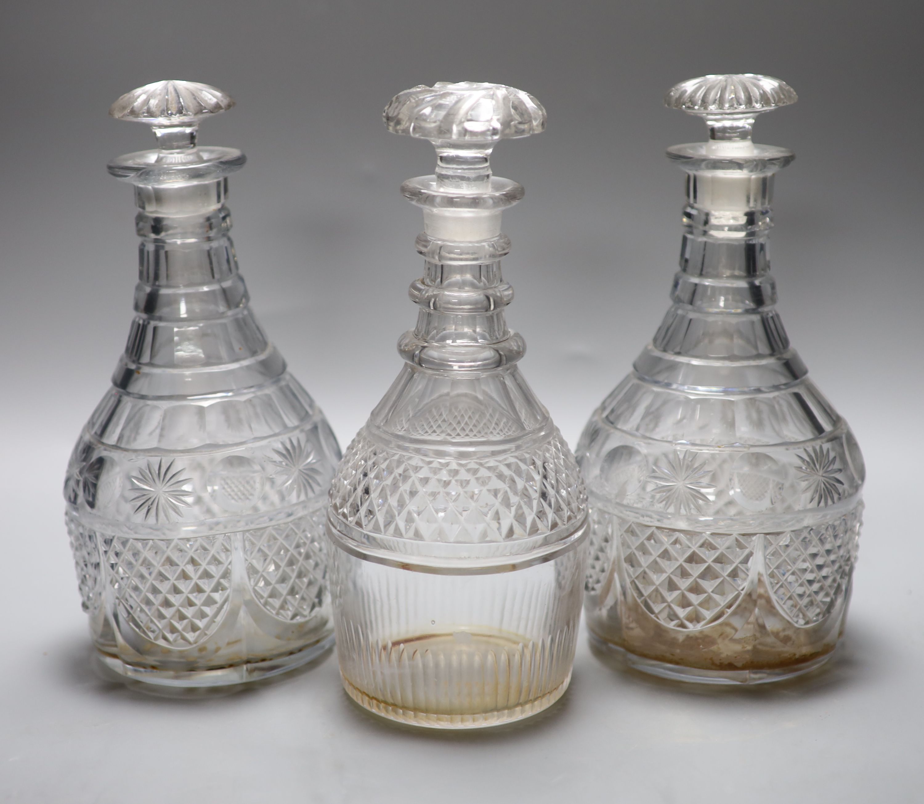 A pair of early 19th century cut glass decanters and one other
