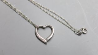 A modern 9ct white gold and diamond chip set openwork heart pendant, 18mm, on a 9ct white gold