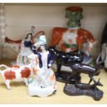 Three Staffordshire cow creamers, a similar cow group and a pair of spaniel groups