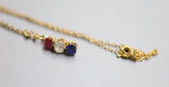 A yellow metal, ruby, diamond and sapphire set line pendant, 14mm, on a yellow metal chain, 38cm,