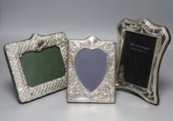 Three modern shaped and embossed silver easel photograph frames, one rectangular with heart-shaped