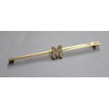 A yellow metal and diamond set initial 'M' bar brooch, 77mm, gross 4.6 grams.