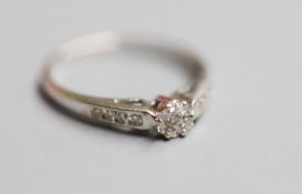 A modern 18ct white metal and diamond cluster ring, with diamond set shoulders, size O, gross 2.5