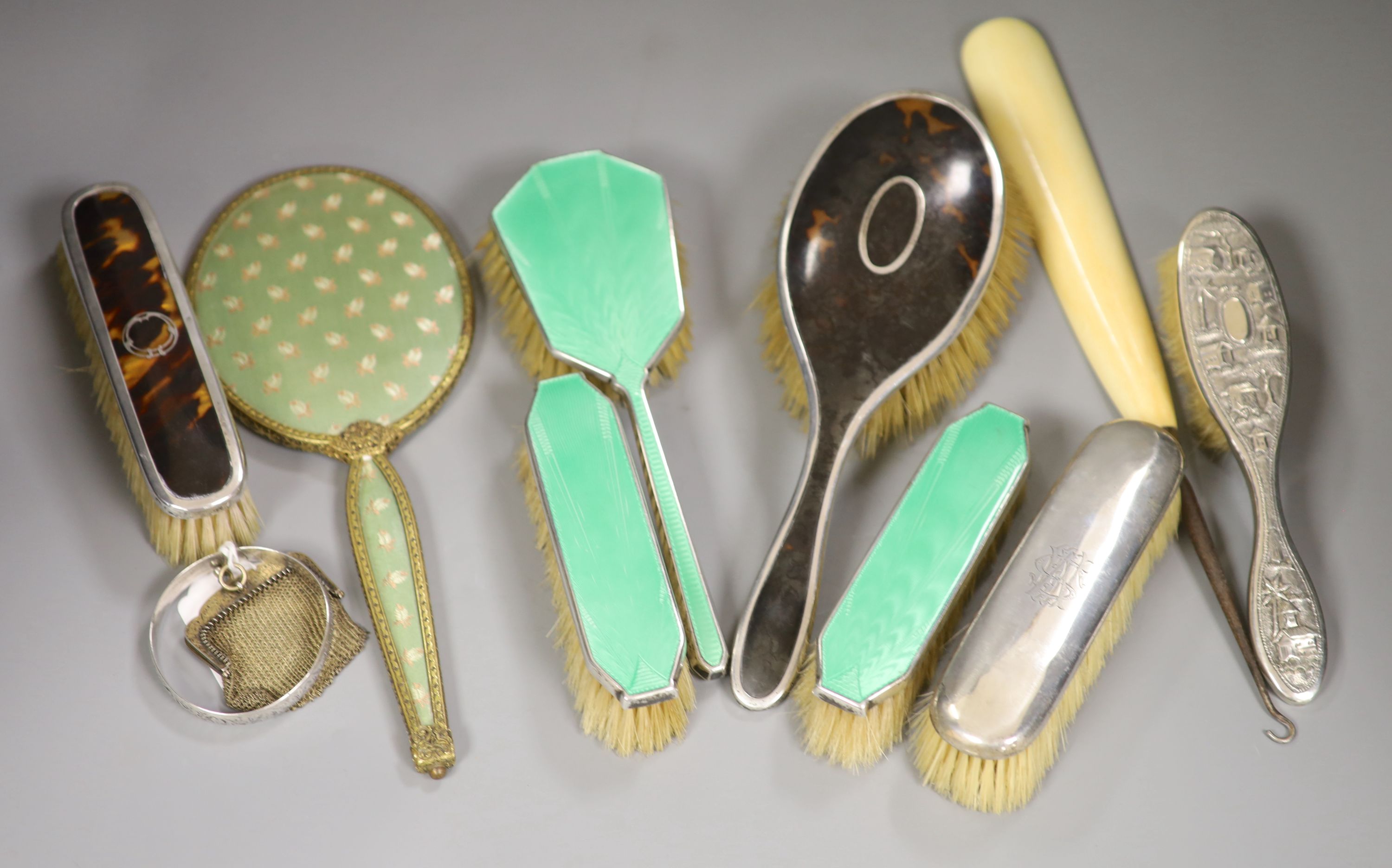 A guilloche enamel and silver-mounted three-piece brush and comb set, three other silver-mounted