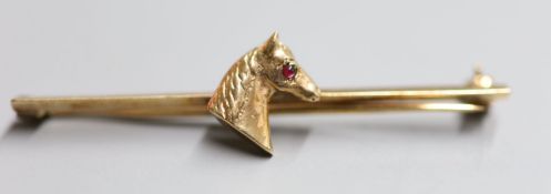A yellow metal tiepin with horse's head inset cabochon ruby eye, 50mm, gross 3.7 grams.