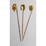 Three assorted Edwardian yellow metal stick pins, one set with diamond chip, 59mm et infra, gross