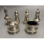 A George V three piece silver condiment set, Birmingham, 1935 and three other silver pepperettes,