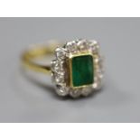 An emerald and diamond cluster ring, white and yellow metal setting (tests as 18ct), size Q, gross