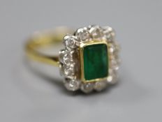 An emerald and diamond cluster ring, white and yellow metal setting (tests as 18ct), size Q, gross