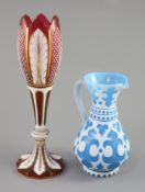 A Bohemian blue and white overlaid glass jug and a similar ruby and white overlaid glass vase,