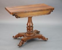 A William IV faded rosewood folding card table, with D shaped folding top, on turned and carved stem