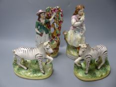 A Staffordshire figure of a female grape picker with vine bocage and three other figures,