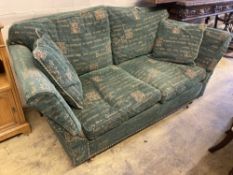 A modern contemporary upholstered two seater sofa upholstered in patterned green fabric, length