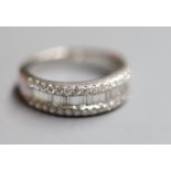 A modern 18k, baguette and round brilliant cut diamond set three row half eternity ring by Butani,