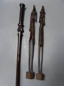 A pair of ebony African sculptures and a carved baton, longest 56cm