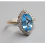 A yellow metal, blue topaz and diamond chip set marquise dress ring, size O, gross 4.2 grams.