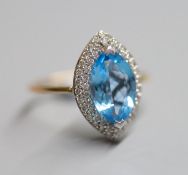 A yellow metal, blue topaz and diamond chip set marquise dress ring, size O, gross 4.2 grams.