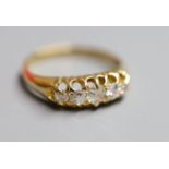 An early 20th century 18ct gold and graduated five stone diamond set half hoop ring, size P, gross 4