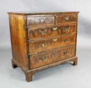 A George III featherbanded walnut chest of two short and three graduated long drawers, on bracket