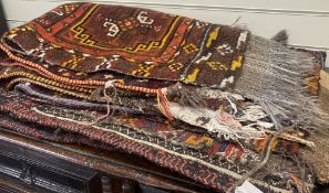 Six Caucasian design mats and a saddlebag, largest 140 x 60cm