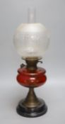 A 19th century oil lamp with a cranberry reservoir