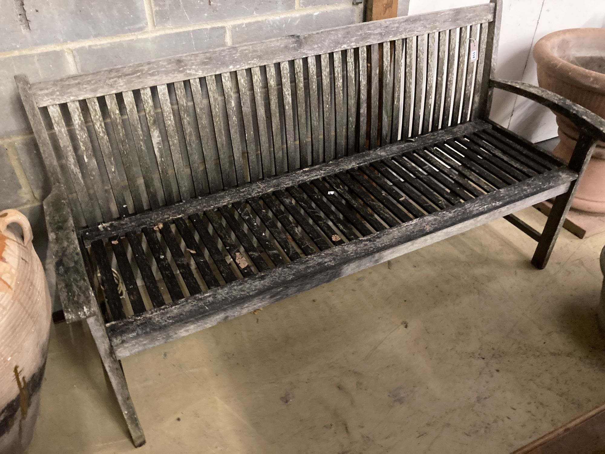 A weathered teak garden bench, length 166cm, width 50cm, height 90cm