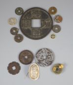 A group of Japanese bronze coin charms or amulets, 19th/20th century, most in bronze, largest