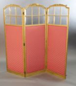 An early 20th century French giltwood three fold dressing screen, carved with ribbons and laurel
