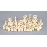 A 19th century Muslim ivory chess set, the two sides with engraved red and brown geometric motifs,