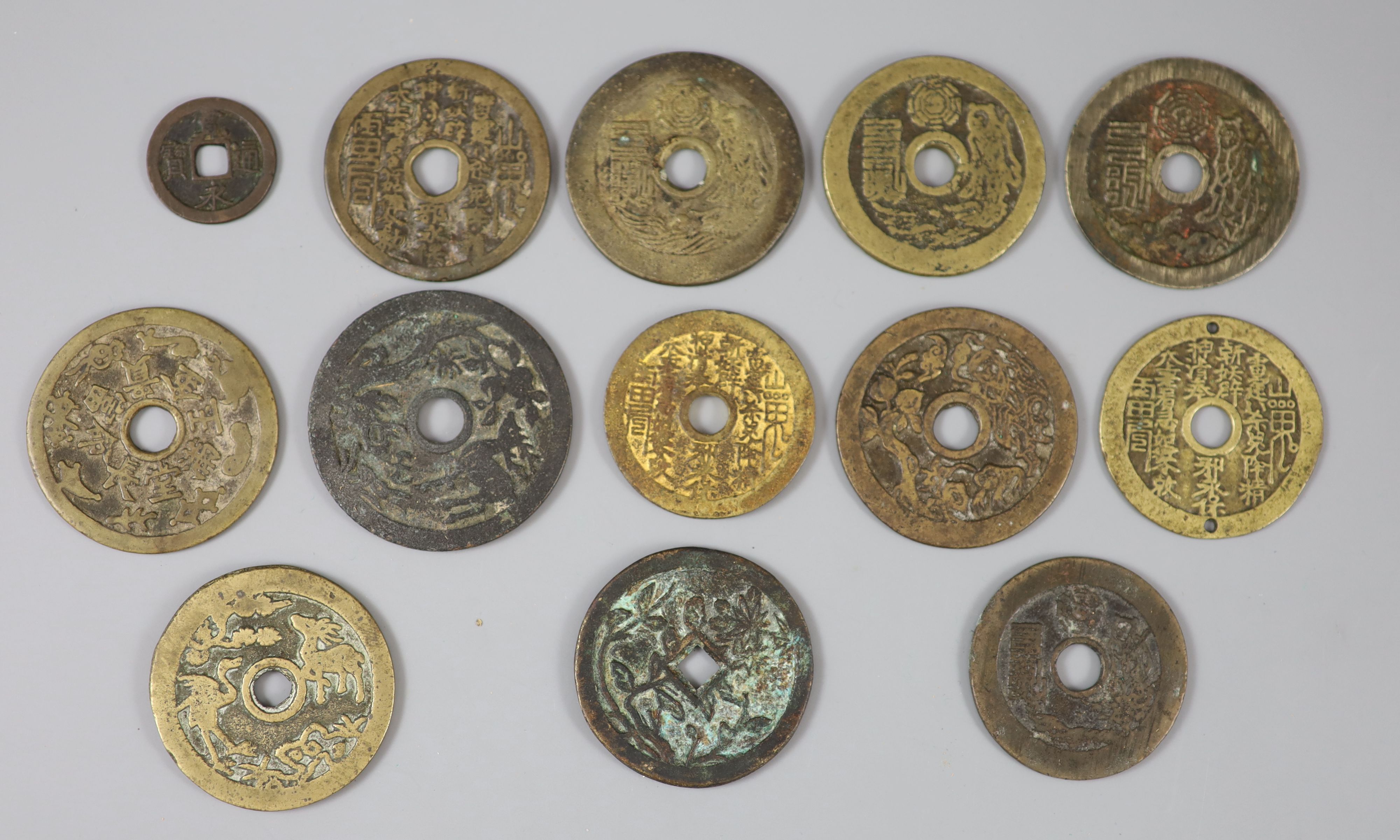 China, 12 cast bronze charms or amulets, Qing dynasty, seven inscribed 'Tai Shang zhou yue..',