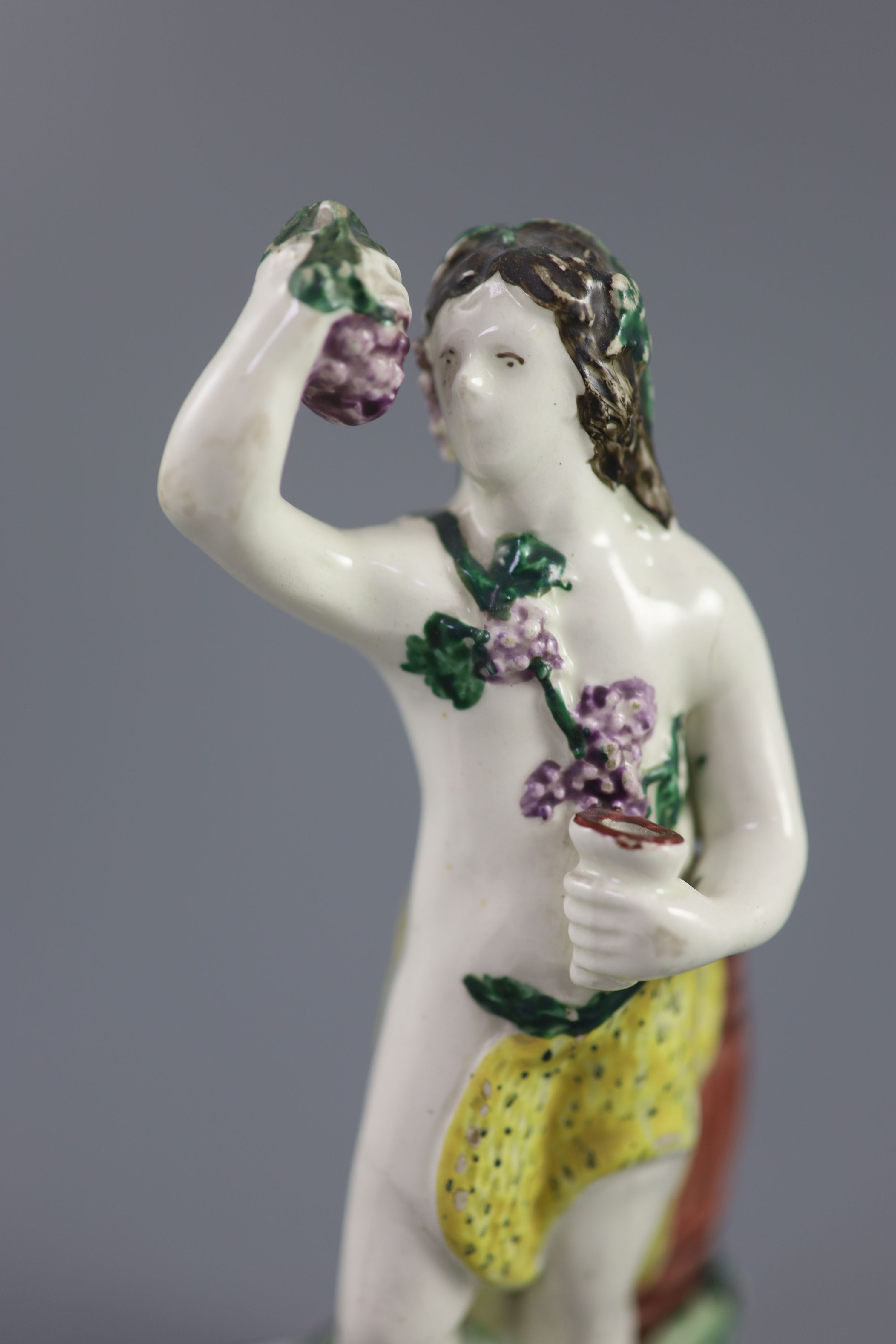 An enamelled creamware figure of Bacchus, attributed Leeds Pottery, c.1790-1800, standing by wine - Image 2 of 4