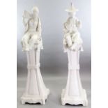 A pair of Continental tin glazed pottery figures of a Chinese man and woman, seated upon a bell-