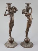 After Edward Francis McCartan (1879-1947). A pair of Art Nouveau bronze candlesticks, modelled as