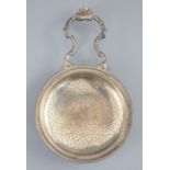 A George III silver single handled lemon strainer, London, 1779, with ornate scroll handle and