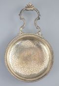 A George III silver single handled lemon strainer, London, 1779, with ornate scroll handle and