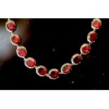 An early 19th century gold and garnet set necklace, set with thirty six oval cut garnets, 38cm,