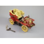 A Bing clockwork tinplate car, c.1906, with cream painted seats, red bodywork and yellow wheels,