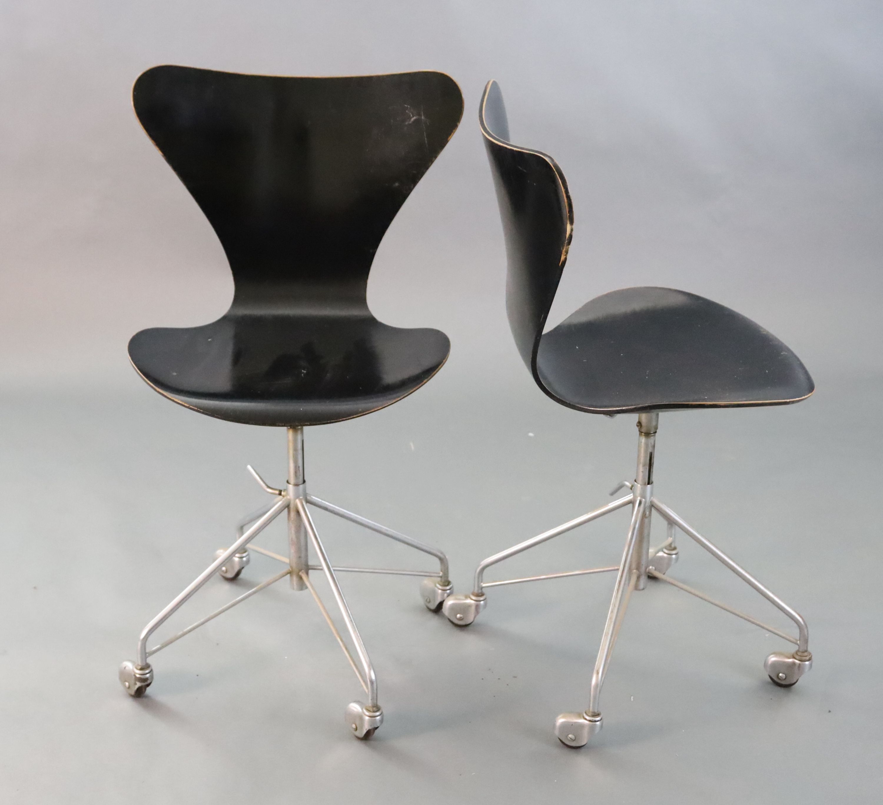 A pair of Arne Jacobsen-style Fritz Hansen 3177 ebonised bentwood revolving desk chairs, on