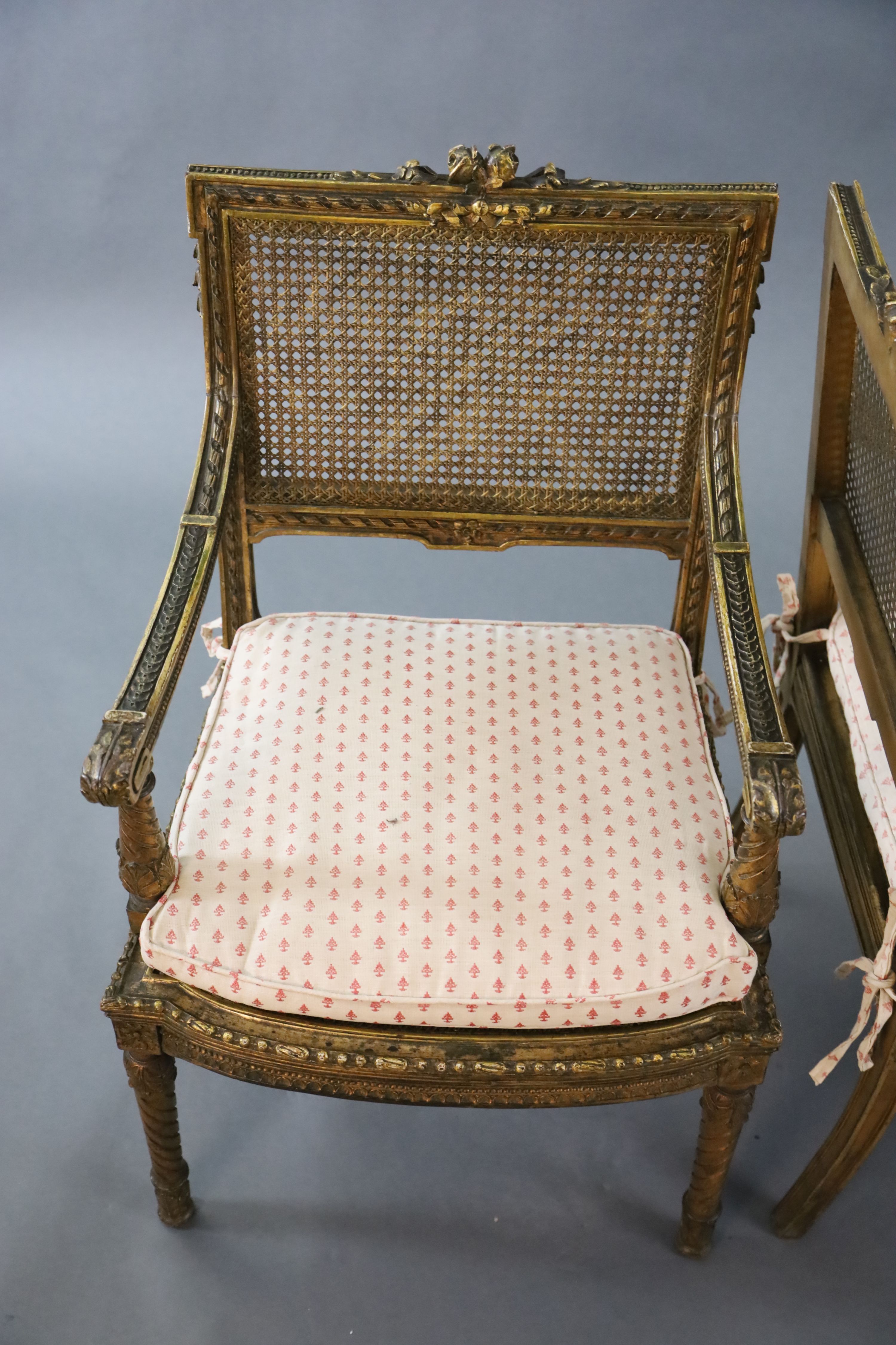 A pair of Louis XVI style walnut giltwood fauteuils, with flower and ribbon carved frames, caned - Image 2 of 4