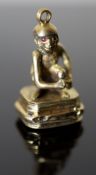 A 19th century gold and black onyx? set fob seal, modelled as a seated monkey with ruby coloured