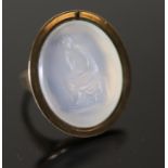 An early 19th century gold and white agate oval intaglio ring, carved with a seated figure, size