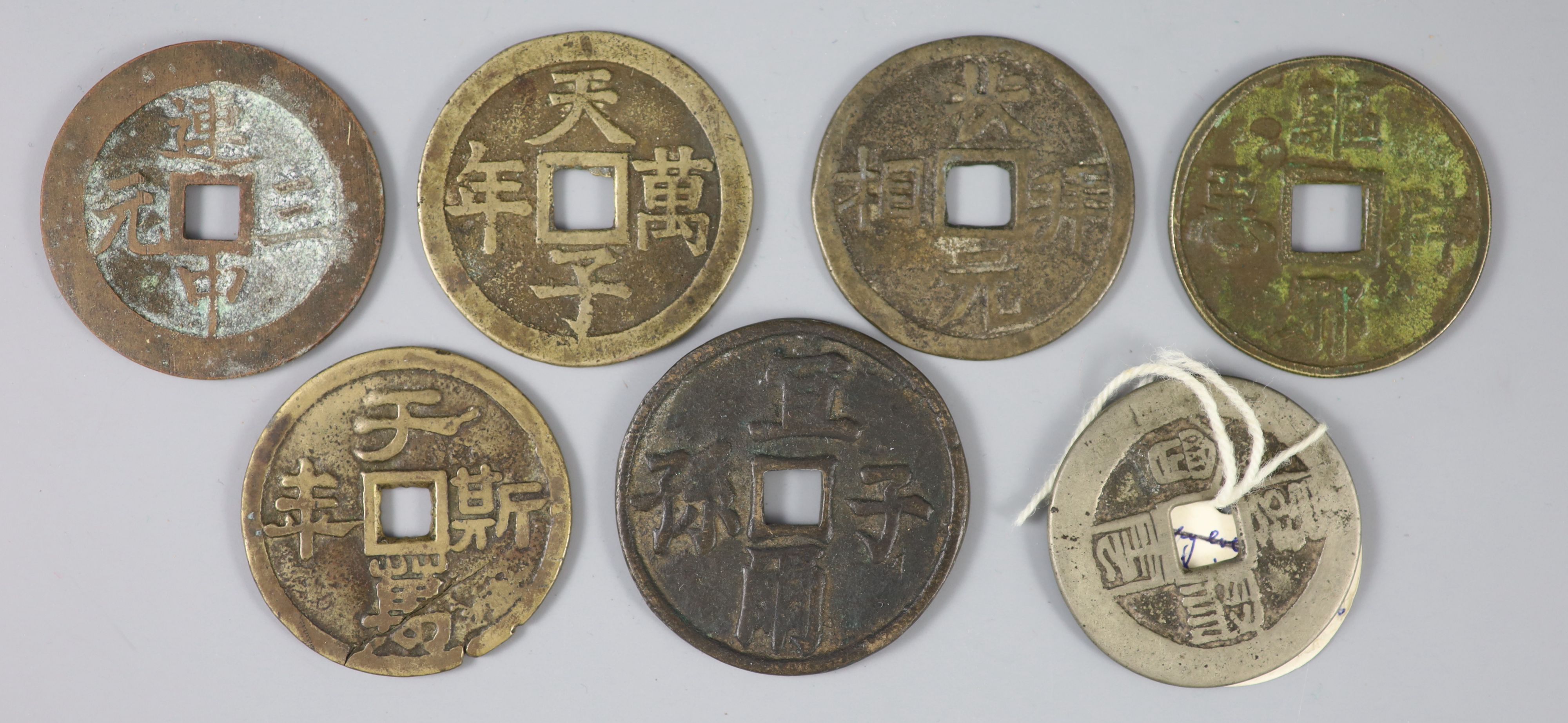 China, a group of 7 bronze charms or amulets, Qing dynasty, each with a four character inscription