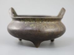 A Chinese bronze tripod censer, Xuande mark but 19th century, with a pair of high-looped handles, on