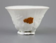 A Chinese Dehua blanc de chine libation cup, moulded as a curled leaf with with leaves, buds and