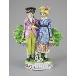 A Staffordshire pearlware group of a Dandy and Dandizette with seated dog, c.1820-30, each