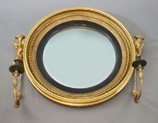 A William IV giltwood and gesso convex girandole, with ropetwist frame, ebonised slip and foliate