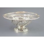 A George III pierced silver pedestal bread basket, with oval ring swing handle, with star, flower