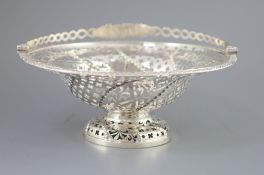 A George III pierced silver pedestal bread basket, with oval ring swing handle, with star, flower